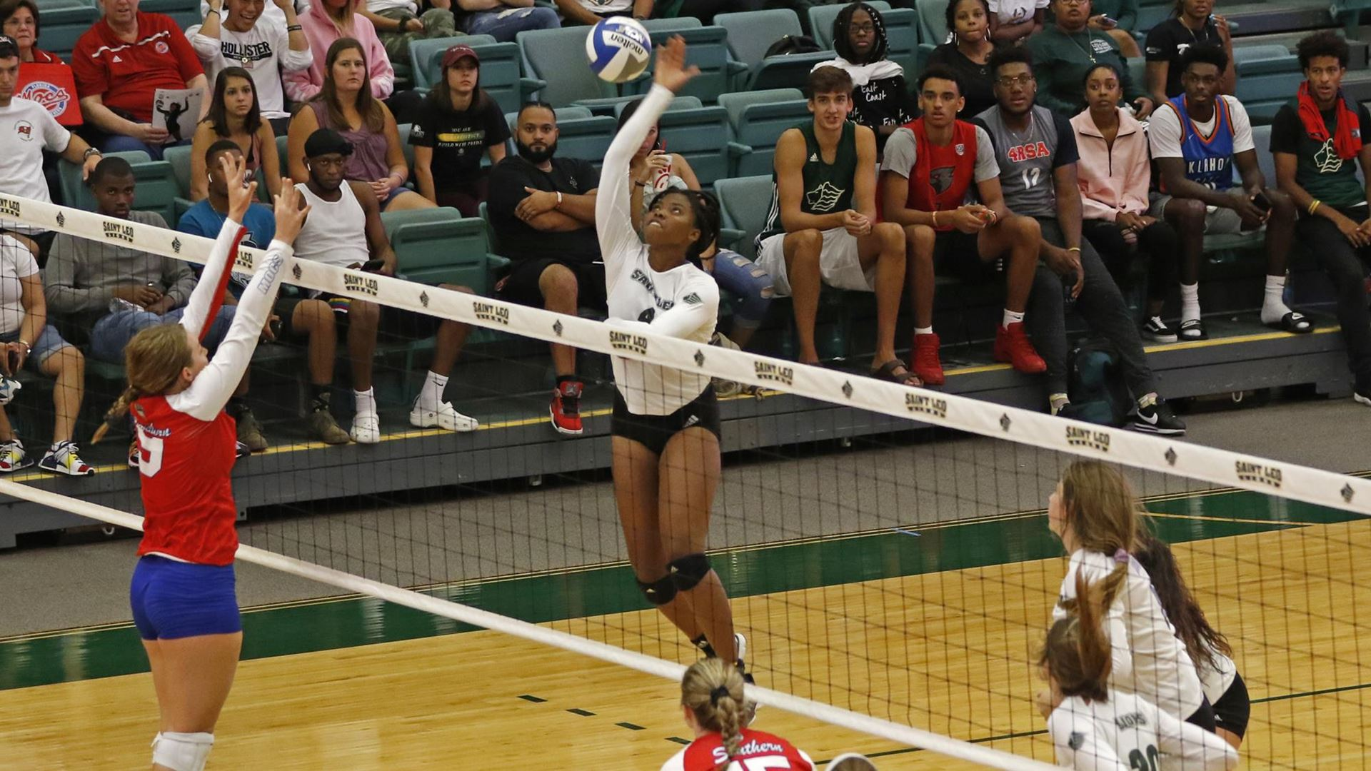 Victoria Omoregie jumping to return volleyball.
