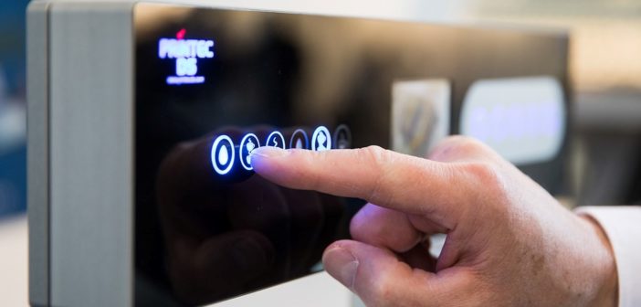 A hand touching a automated coffee maker touchscreen