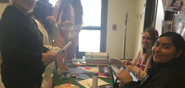 Saint Leo Students making rain sticks smiling at camera