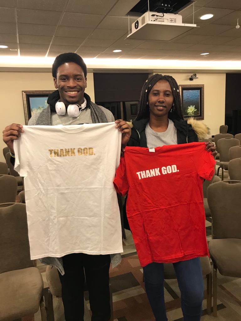Two students holding tshirts.