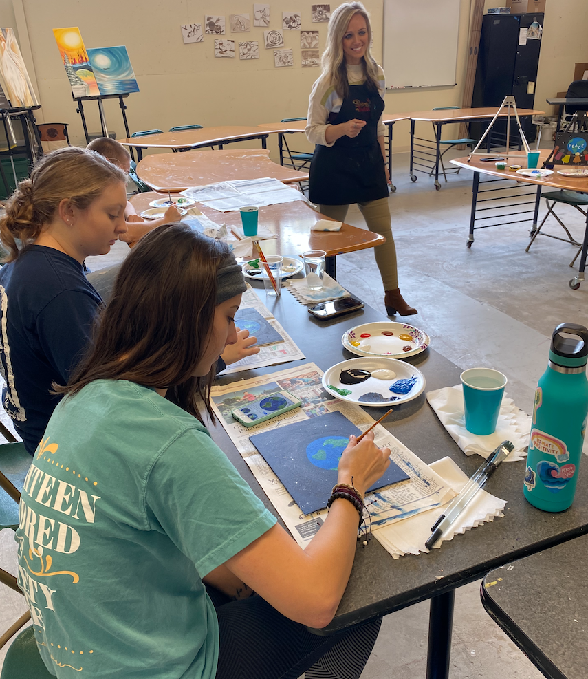 Instructor and two students in an art event.