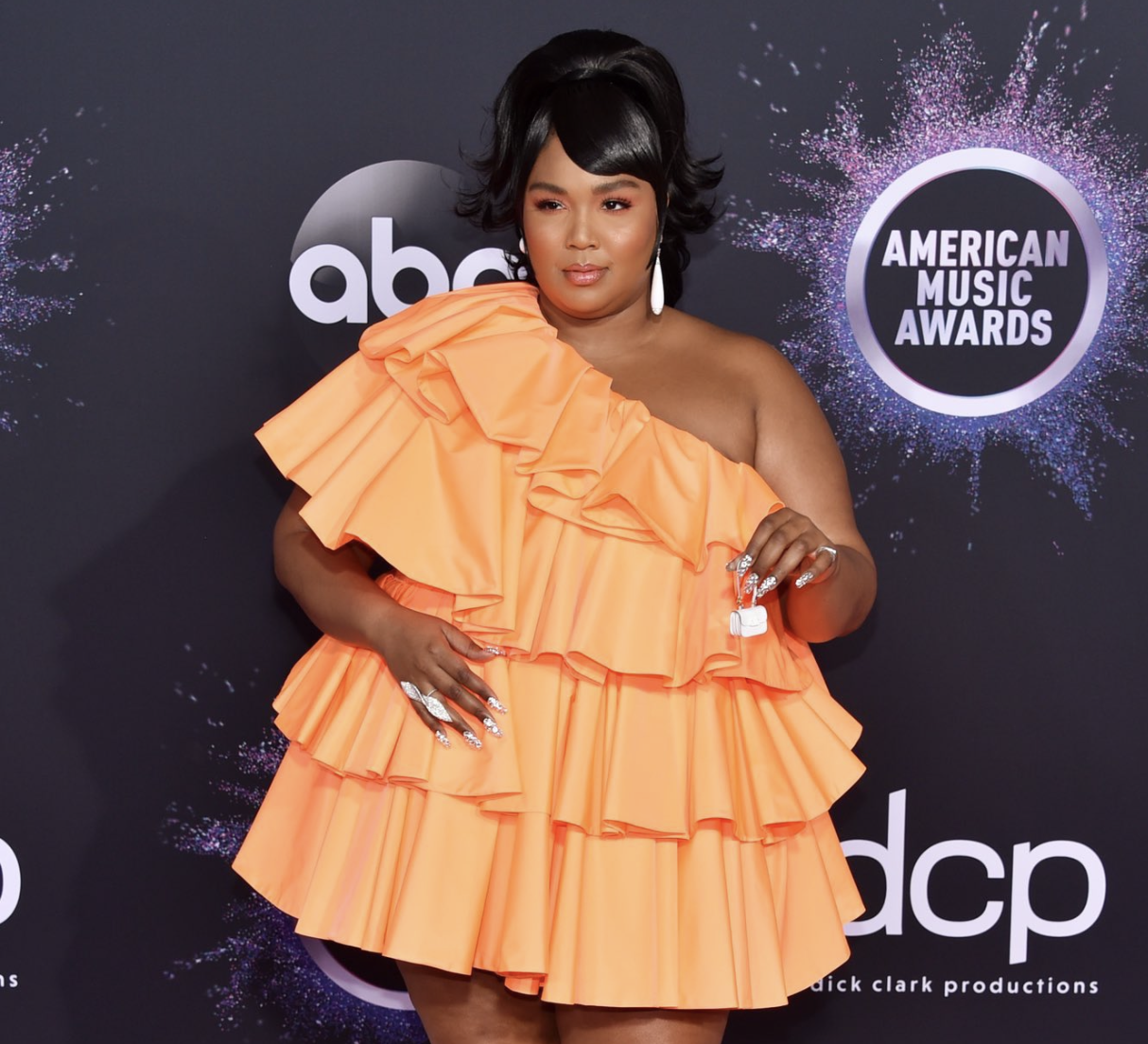 Lizzo in an orange spiral dress.