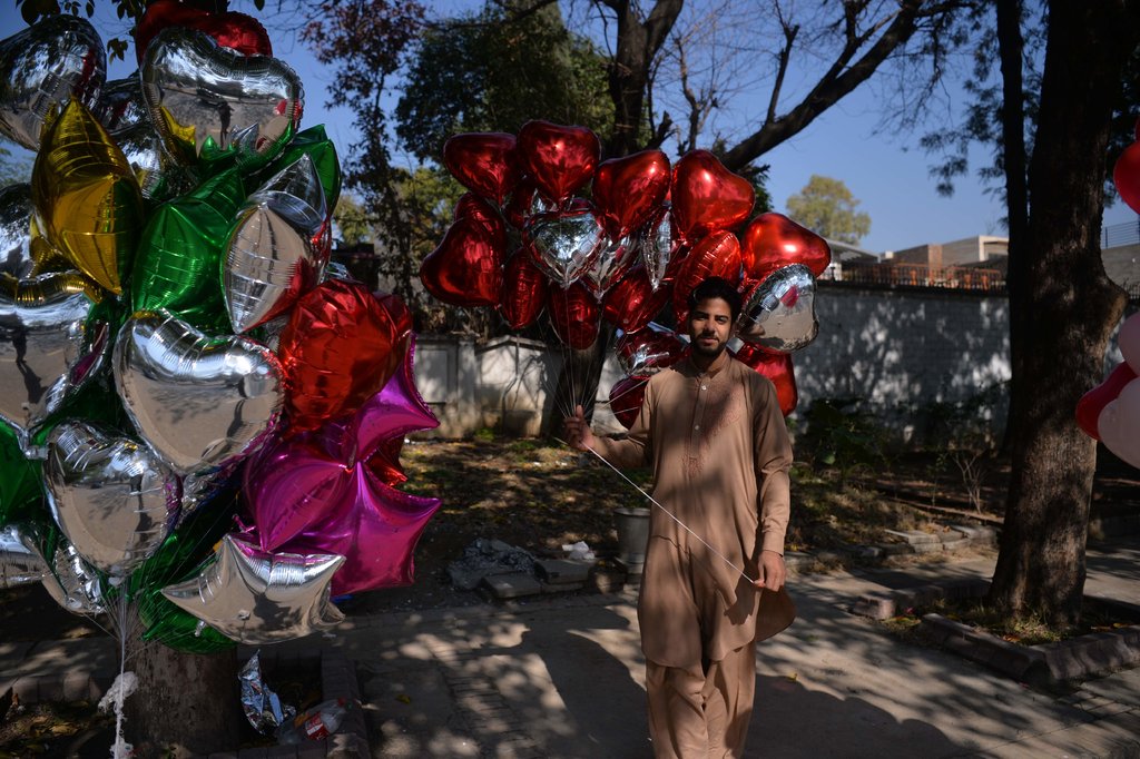 A man selling Valentine's Day helium filled balloons.