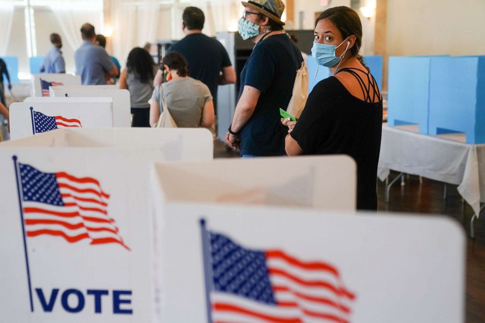 Citizens can still choose to vote in-person, but they must continue social distancing, wear a mask, and sanitize. Photo source: (Elijah Nouvelage – Getty Images)