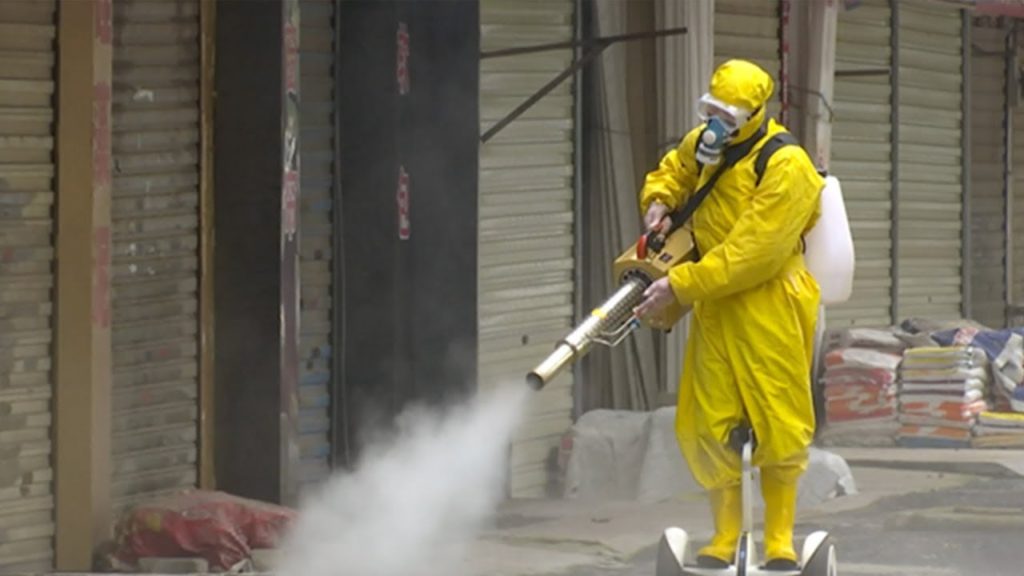 Someone wearing a hazmat suit deep cleaning an area