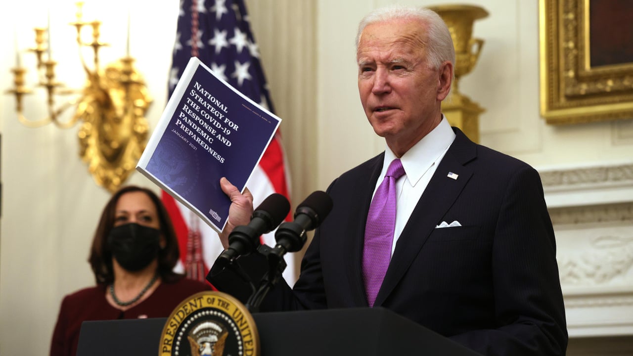 President Joe Biden holding documents with right hand