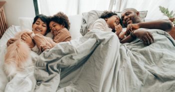 A family, a mother, father, and two children in bed