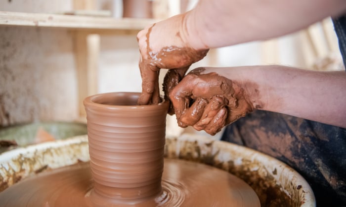 Two hands working with a clay mold.