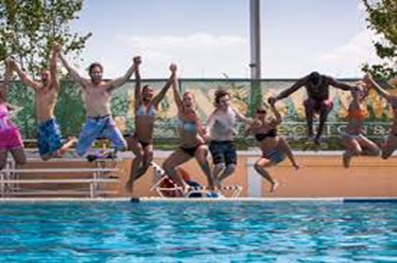 Students jumping into pool holding hands