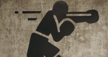 An image of a boxer throwing a punch silhouetted on the wall