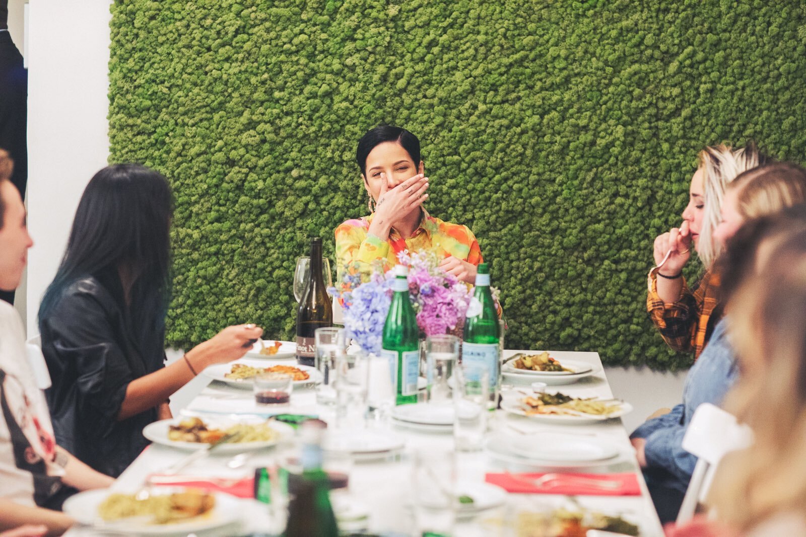 Artist Halsey with people talking around a table