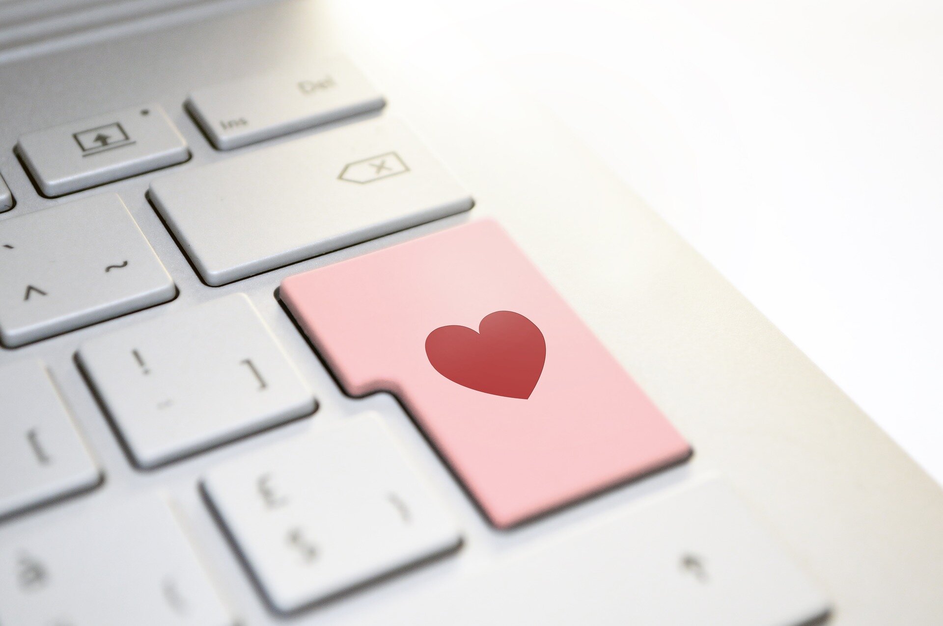 Laptop keyboard with the enter key in pink with a red heart