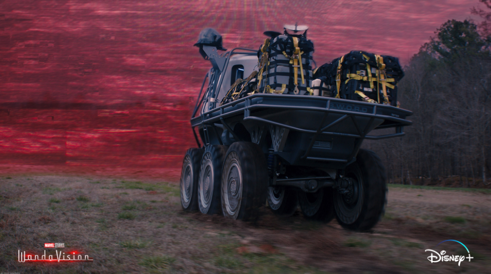 An armored tank driving at a mysterious red energy field