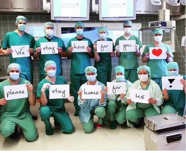 Medical professionals wearing masks holding signs