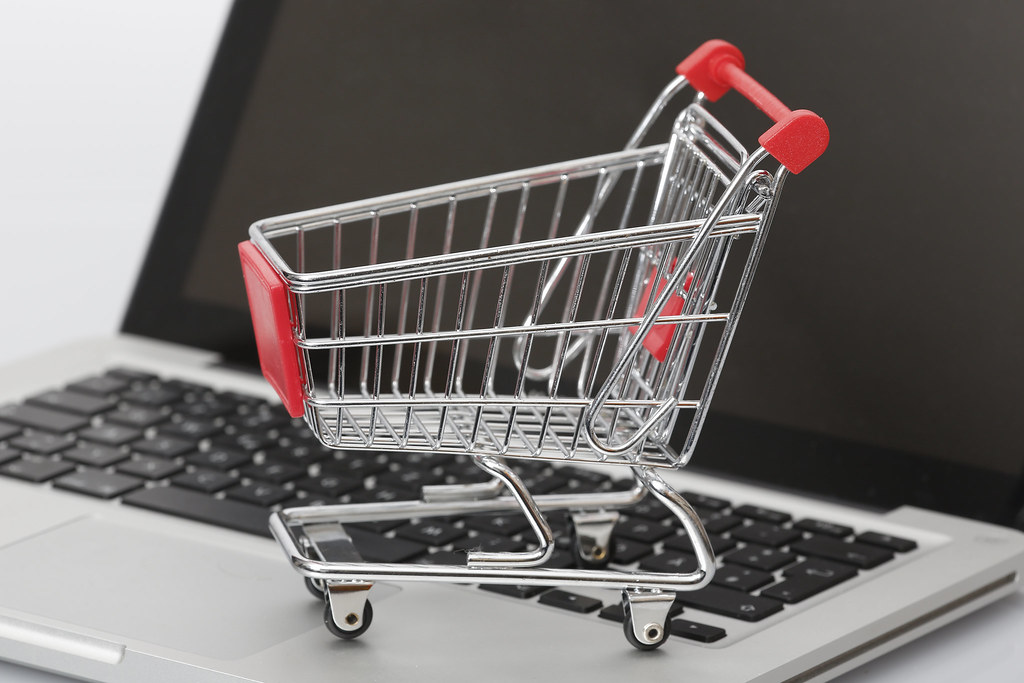 A shopping cart on top of a laptop