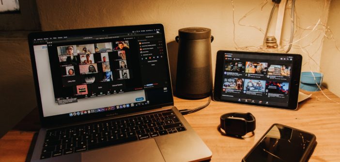 A laptop with Zoom in the backgound on a desk